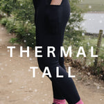 A person wearing tall thermal black leggings with a thick waistband, standing outdoors with snow falling and wearing brown boots.