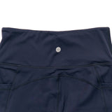 Navy blue capri leggings with a badge on a white background
