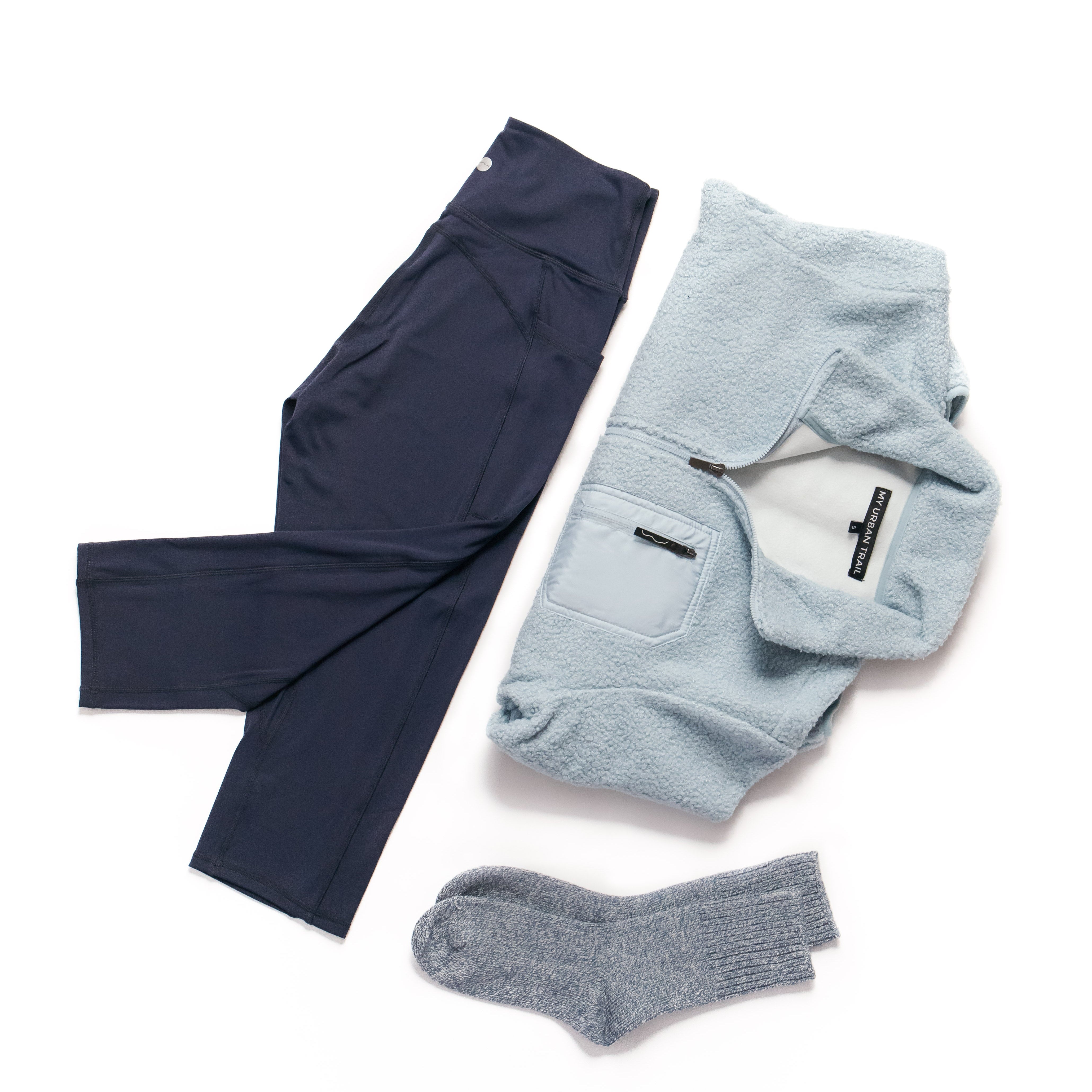 Navy pants, light blue sweater, and gray socks on a white background