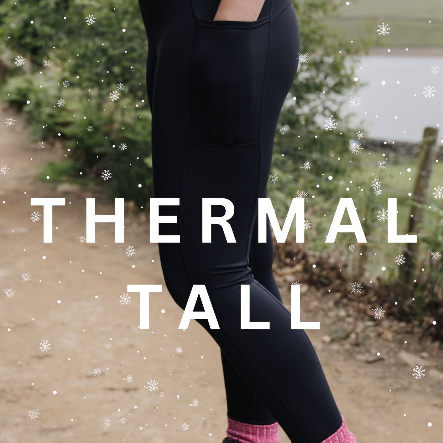 A person wearing tall thermal black leggings with a thick waistband, standing outdoors with snow falling and wearing brown boots.
