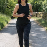 Woman running on a path surrounded by greenery