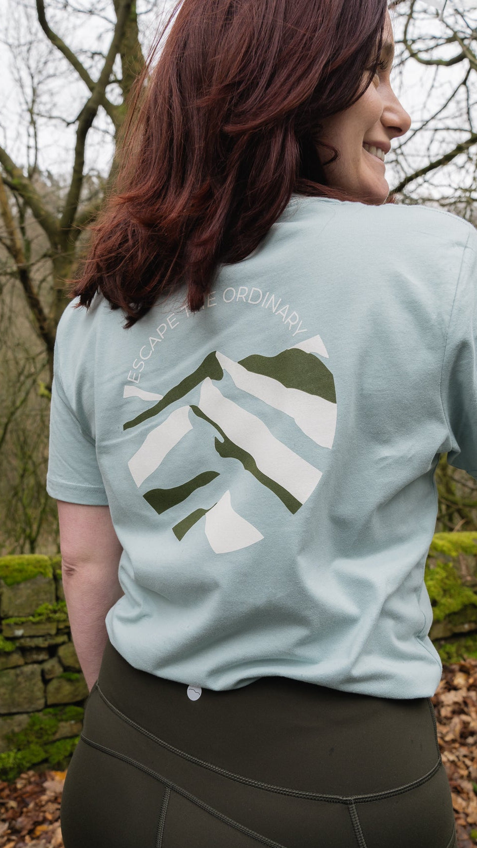 Person wearing a light blue t-shirt with a design outdoors