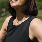 Woman wearing sunglasses and a black tank top outdoors