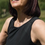 Woman wearing sunglasses and a black tank top outdoors