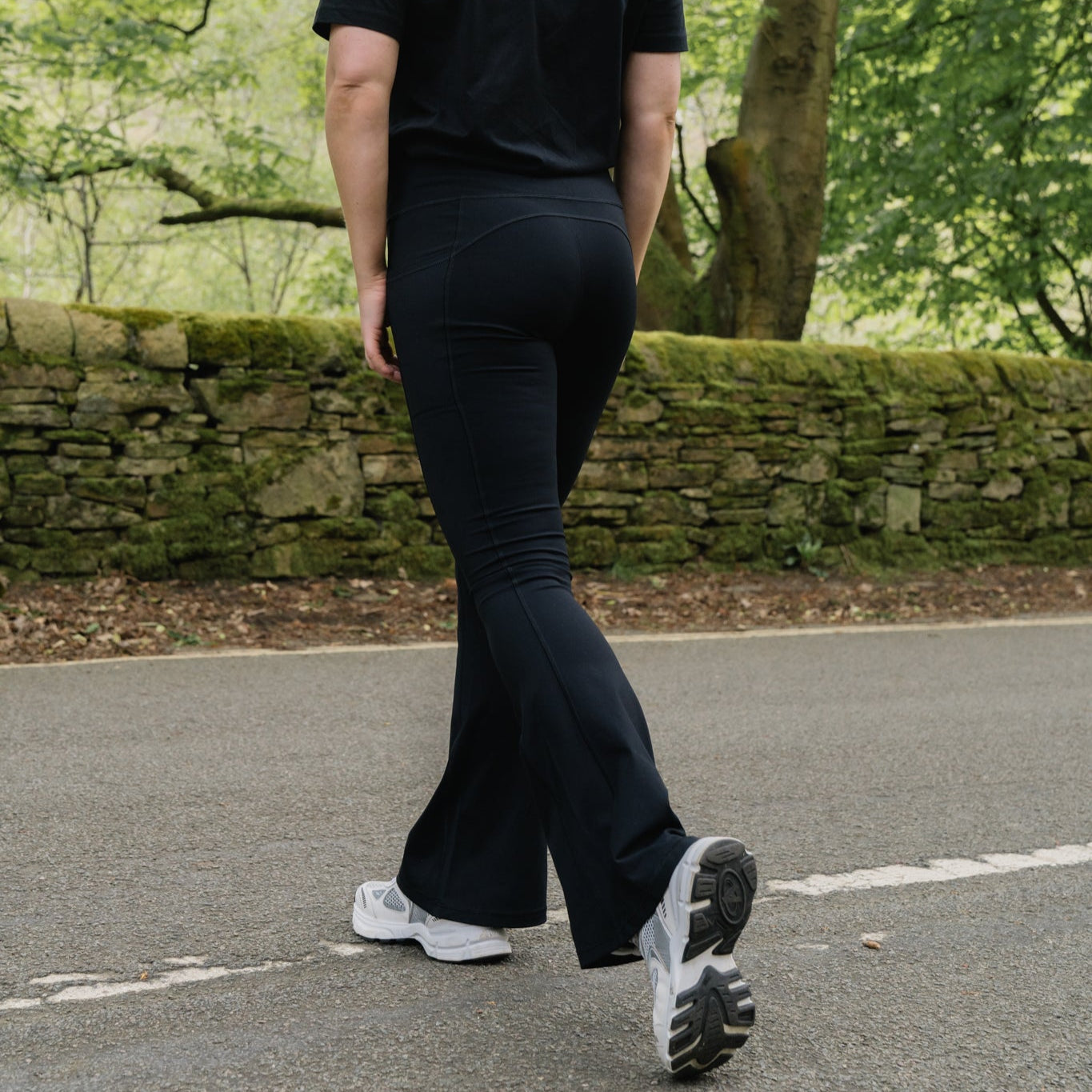 walking across the road in black flares
