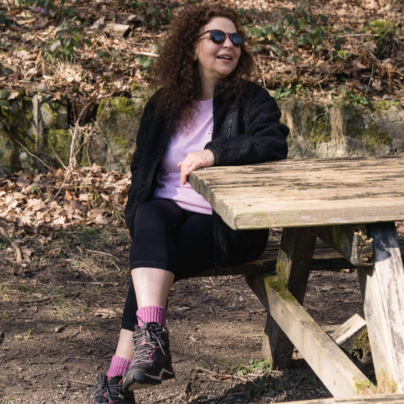 woman sat at picnic bench in capri leggings
