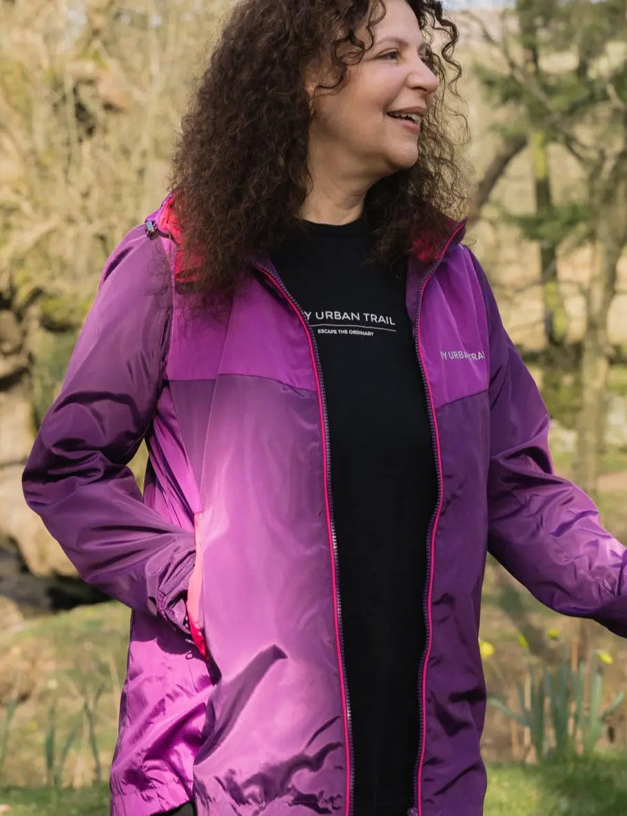 woman wearing purple waterproof and walking pole