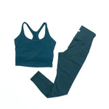 Teal athletic top and leggings set on a white background