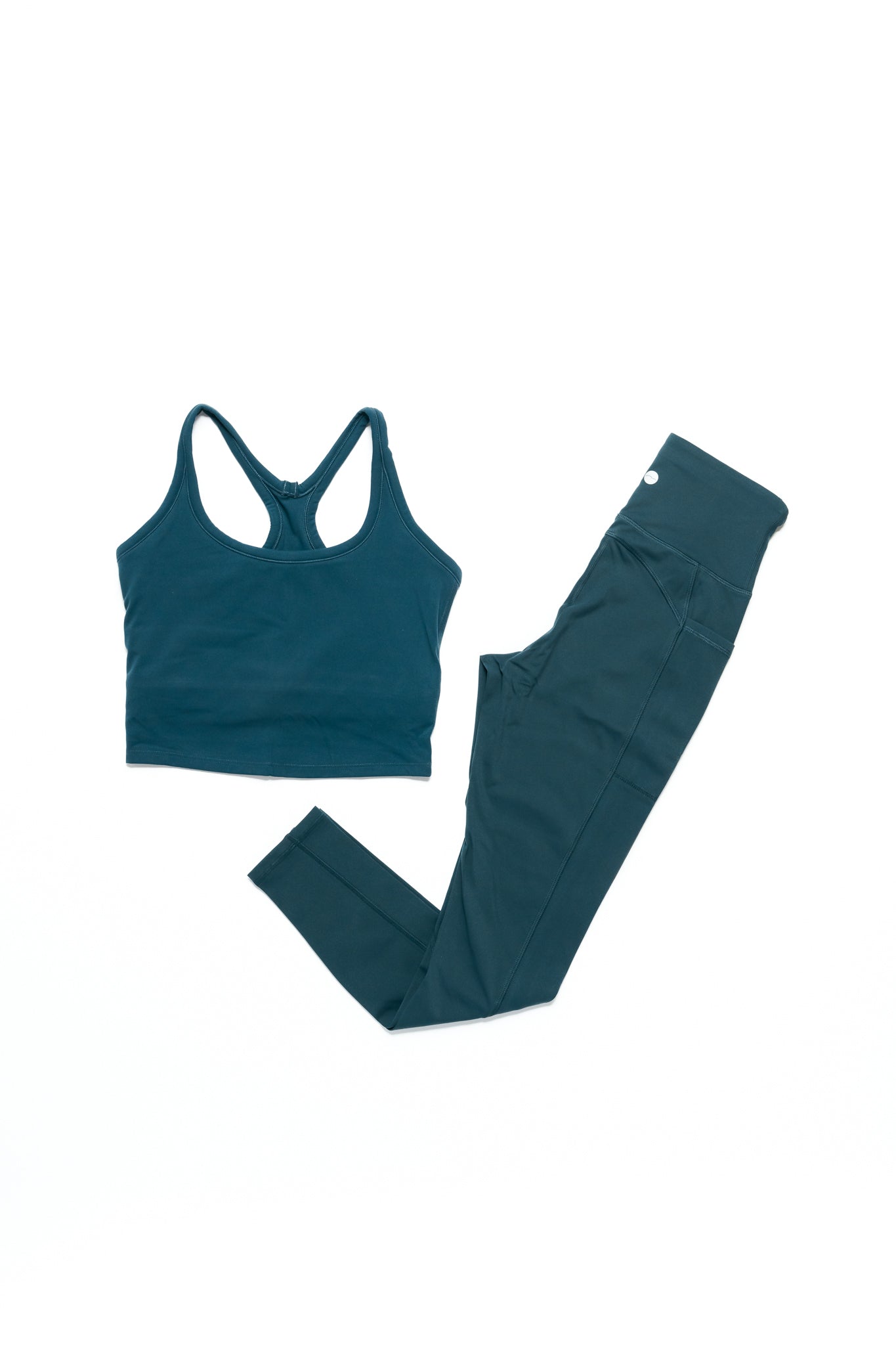Teal athletic top and leggings set on a white background