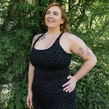 Woman wearing a black dress standing in a forested area