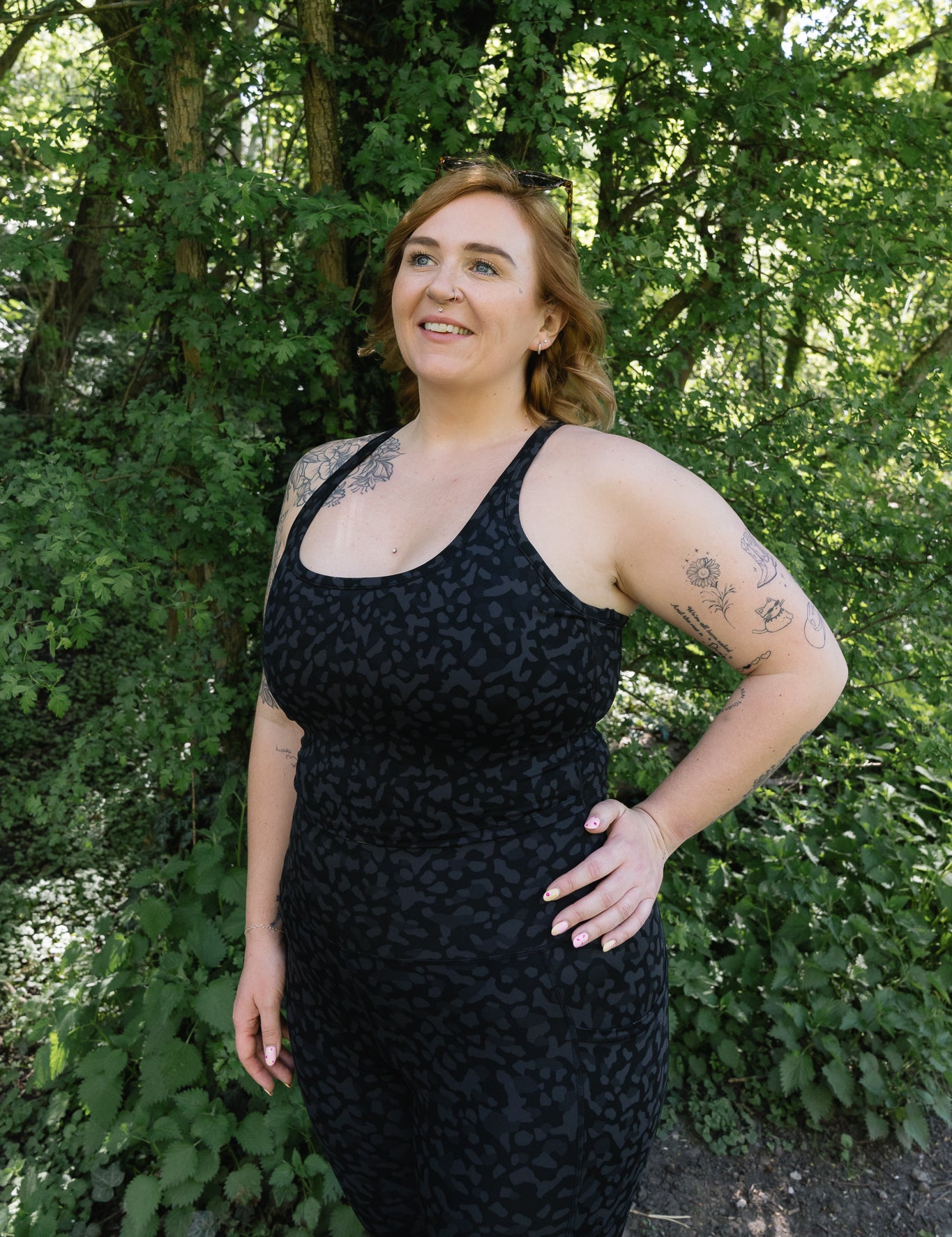 Woman wearing a black dress standing in a forested area