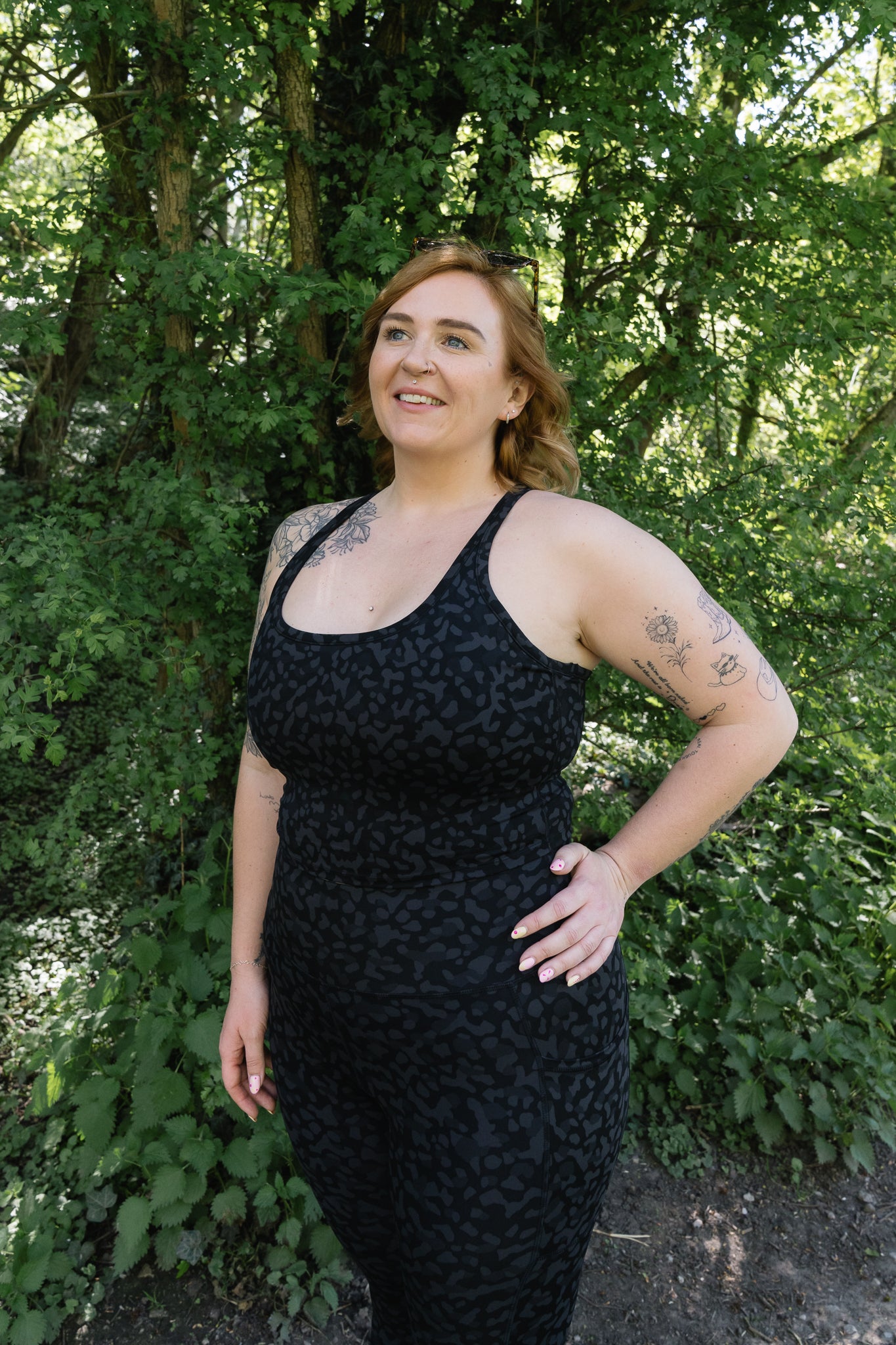 Woman wearing a black dress standing in a forested area
