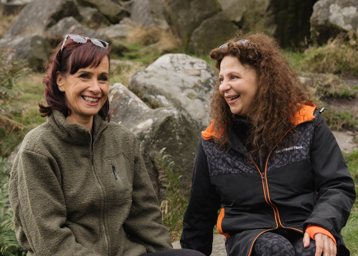 Two women sitting outdoors in a rocky landscape