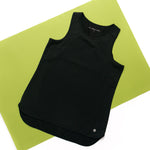 Black sleeveless top on a green mat